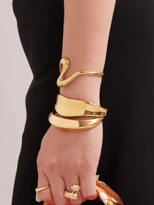 Modelo luce un conjunto de brazaletes de oro de 18K y un anillo con forma de hoja