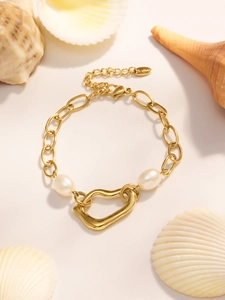 Detail of 18k gold plated stainless steel chain bracelet with pearls and heart pendant