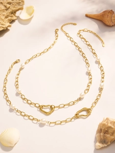 Detail of 18k gold plated chain with white pearls and irregular heart-shaped pendant