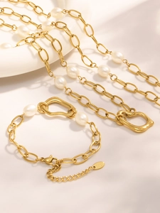 Detail of 18k gold plated stainless steel jewelry set with pearls and irregular charms