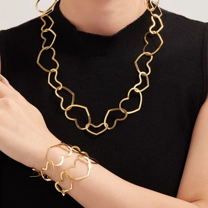 Golden hollow heart link jewelry set featuring a necklace and bracelet on model