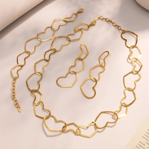 Golden stainless steel jewelry set featuring hollow heart necklace, bracelet, and earrings