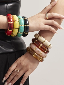 Detail view of colorful resin stretch bracelets with gold-tone metal ring connectors