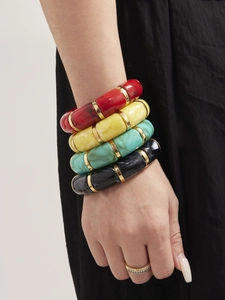 Close-up of four-piece colorful marble resin bangles with gold metal rings on a model