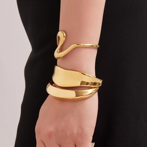 Conjunto de brazaletes de acero inoxidable dorado con curvas en S y textura geométrica