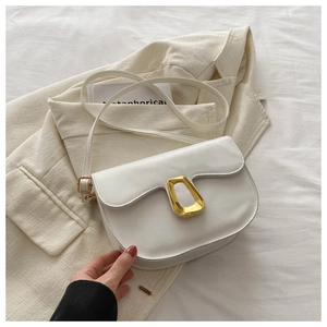 Detail of white PU saddle bag featuring a distinctive gold geometric metal buckle closure