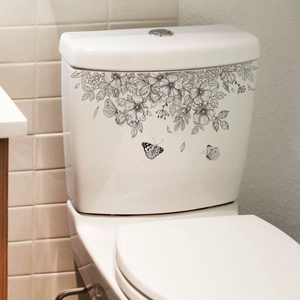 Floral butterfly toilet decal in black and white line art on a white ceramic tank