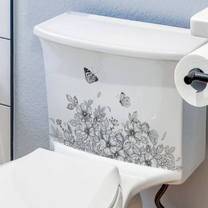Black and white floral and butterfly wall stickers applied on a white toilet tank