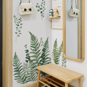 Detail of watercolor green leaf wall stickers in a minimalist home entryway setting