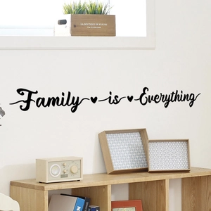 Dettaglio dell'adesivo murale Family is Everything con cuori in un soggiorno