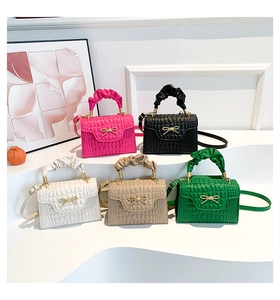 Close-up of crocodile pattern mini handbags in multiple colors with bow and cloud handles