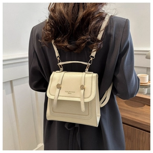 Detail eines beigen PU-Leder-Rucksacks mit goldenen Schnallen und TidalDryness-Logo