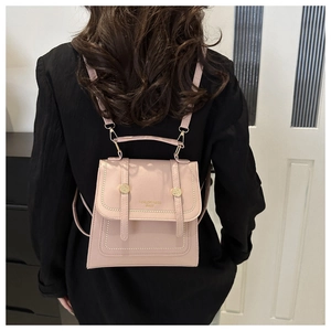 Pink PU leather backpack featuring flap design with decorative straps and gold stud details