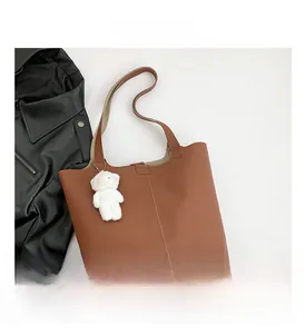 Brown lychee grain leather tote bag with vertical stitching and cute bear charm detail