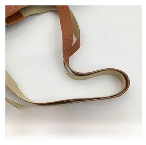 Close-up of brown litchi pattern leather shoulder strap on a large tote bag
