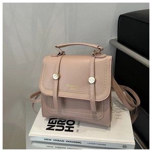 Details der altrosa Handtasche mit verstärktem Griff und goldenem Markenlogo