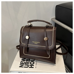 Detail der dunkelbraunen Ledertasche mit Retro-Nähten und Metall-Schnallenverschlüssen