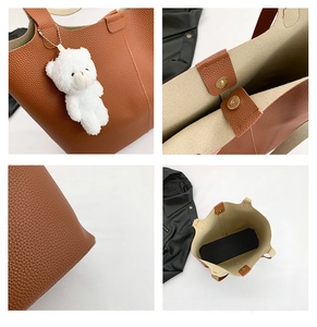 Detail of caramel tote bag showing lychee grain leather, magnetic clasp, and bear charm