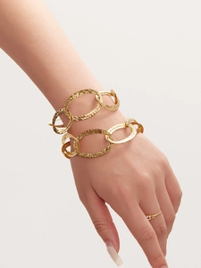 Dettaglio del bracciale a catena a doppia maglia dorata martellata sul polso