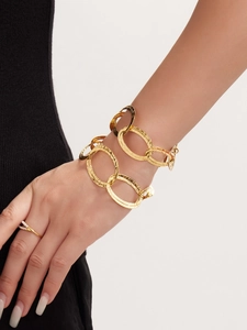 Dettaglio del bracciale a maglie martellate dorate a due strati e anello sottile