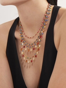 Detail of multilayer gold evil eye necklace with colorful beads on a model