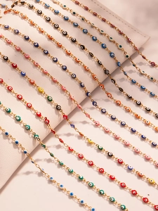 Macro detail of multi-color evil eye beads on gold stainless steel chains