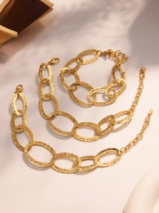 Dettaglio del bracciale a doppia catena con maglie ovali martellate e chiusura dorata