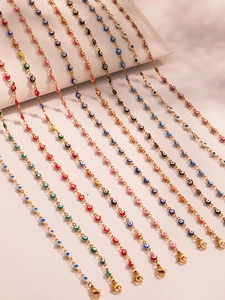 Macro detail of colorful enamel evil eye charms on dainty gold-plated stainless steel chains