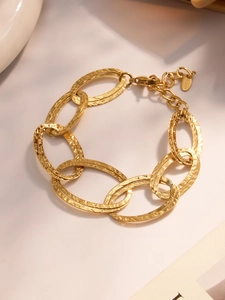 Dettaglio del bracciale in acciaio inossidabile dorato con maglie martellate e moschettone