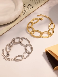 Dettaglio di bracciali in acciaio inossidabile martellato oro e argento con chiusura a moschettone