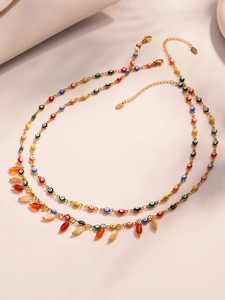 Detailed macro view of colorful evil eye beads and water drop pendants on gold chains