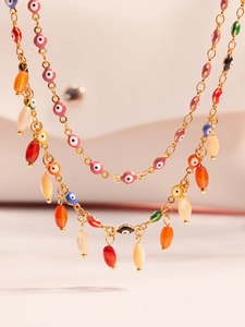 Macro detail of gold stainless steel necklace with multi-color Turkish evil eye beads