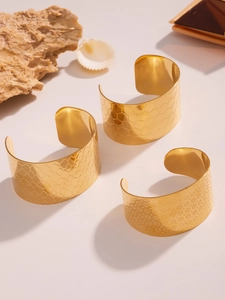 Λεπτομέρεια από επιχρυσωμένα βραχιόλια 18k με σχέδια κηρήθρας, λεπιδιών και λουλουδιών