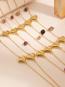 Detail of gold heart pendant necklace with colorful natural stone beads and long chain