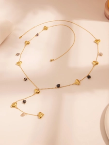 Detailed view of long Y-shaped gold necklace with heart charms and natural stone beads