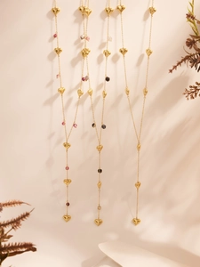 Golden heart necklace with purple natural stone charms and dried flower background