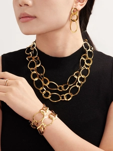 Détail d'un ensemble de bijoux géométriques plaqués or 18 carats porté par un mannequin