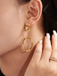 Détail de boucles d'oreilles géométriques plaquées or 18 carats sur un mannequin