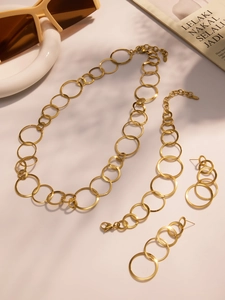 Details des goldenen Schmucksets mit Halskette, Armband und Ohrringen im Kreisdesign