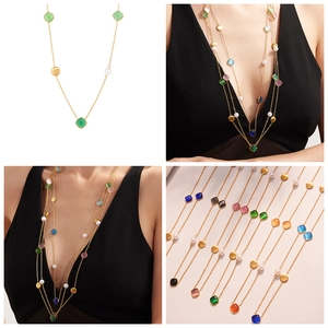 Detail of gold chain necklace featuring colorful square crystals and small white pearls