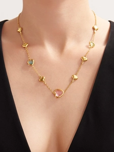 Detail of 18k gold plated heart necklace with faceted colorful glass stones on model