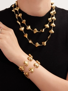 Close-up of a 18k gold plated stainless steel hollow heart necklace and bracelet set