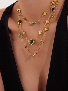 Detailed view of triple-layered 18k gold necklace with colorful faceted glass hearts