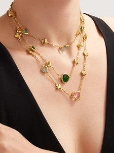 Close-up of triple-layered 18k gold plated necklace with colorful heart-shaped gemstones
