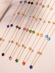 Macro view of colorful crystal pendant necklaces with gold chain and white pearl beads