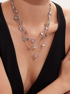 Detailed view of layered silver necklace with multi-colored heart-shaped gemstones and charms