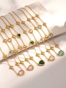 Detail showing 18k gold heart necklaces with multi-color faceted glass stones