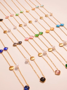 Detailed view of colorful cat-eye stones and white pearls on gold stainless steel chains