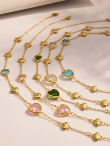 Detailed view of heart necklaces with colorful faceted stones in gold plated steel