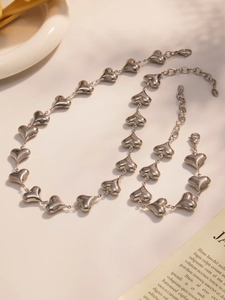 Detail of polished stainless steel heart necklace and bracelet set with lobster clasp